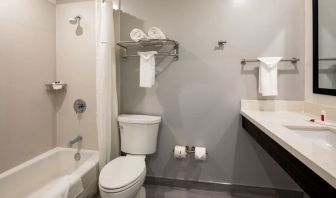 Private guest bathroom with combined shower and tub at Travelodge LAX By Wyndham.