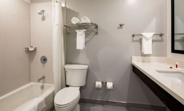 Private guest bathroom with combined shower and tub at Travelodge LAX By Wyndham.