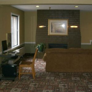 Lobby lounge and workspace with comfortable seating, fireplace and computer at Norwood Inn Minneapolis Roseville.