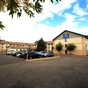 Hotel exterior and parking area at Norwood Inn Minneapolis Roseville.