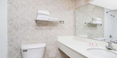 Private guest bathroom with shower and free toiletries at Norwood Inn & Suites La Crosse.
