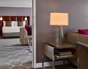 Deluxe king Royal Sonesta Houston Galleria guest room, furnished with coffee table, sofa, and chair.