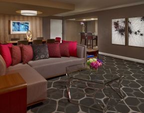 Royal Sonesta Houston Galleria workspace, featuring corner sofa and coffee table, plus long table surrounded by chairs.