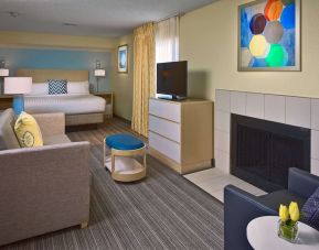 Double bed guest room in Sonesta ES Suites Tucson, including lounge with sofa, armchair, and TV.