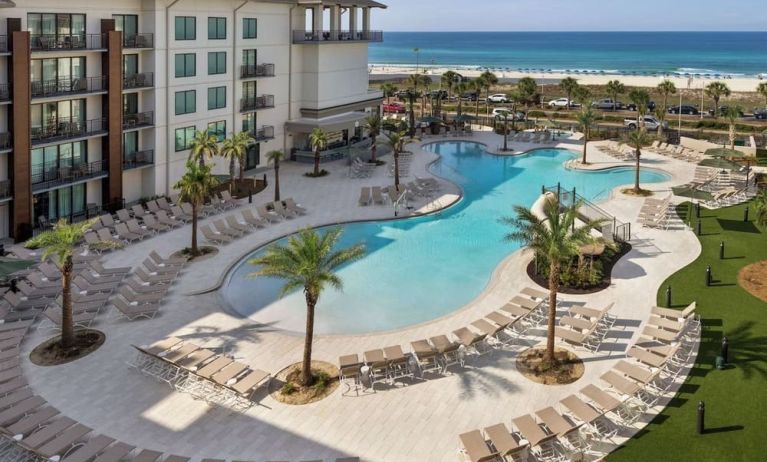 Beautiful outdoor pool with lounge chairs at Embassy Suites By Hilton Panama City Beach Resort.