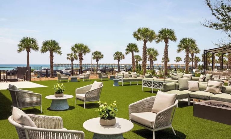 Terrace with sea view and lounge seating at Embassy Suites By Hilton Panama City Beach Resort.