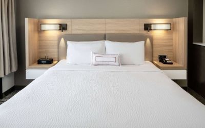 Sonesta Select Nashville Airport Suites deluxe king bed room, featuring bedside lamps and telephone.