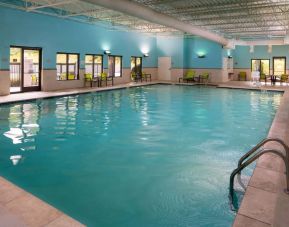 Sonesta Select Nashville Airport Suites’ indoor pool is brightly lit, has chairs by the side, and is adjacent to the patio.