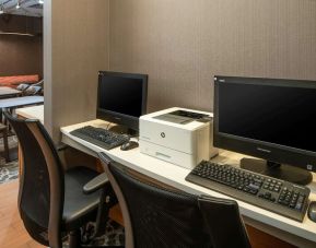 The hotel business center includes a pair of computer workstations and a printer.