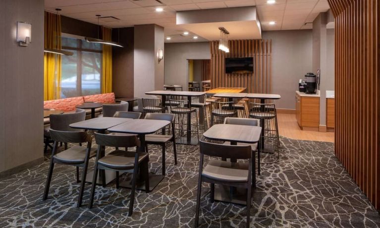 Hotel workspace, including extensive seating and tables for between two and six individuals, and coffee-making facilities.
