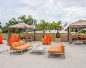 The hotel’s patio has comfortable sofa seating, coffee tables, and potted palm trees.