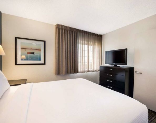 Double bed guest room in Sonesta Simply Suites Silicon Valley - Santa Clara, with widescreen television and window.
