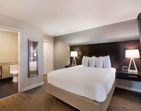 Double bed guest room in Sonesta ES Suites Dulles Airport, with tall mirror and ensuite bathroom.
