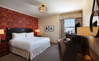 The Stephen F Austin Royal Sonesta Hotel double bed guest room, including window and workspace desk and chair.