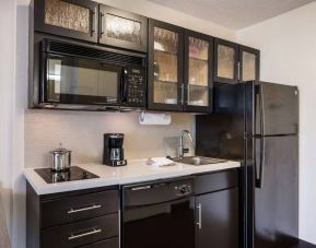 Sonesta Simply Suites Arlington guest room kitchen area, including fridge-freezer, oven, hob, and microwave.