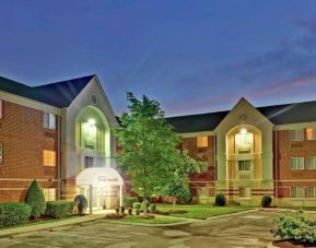 Sonesta Simply Suites Nashville Brentwood’s exterior is brightly lit and has well-tended lawns, bushes, and trees.
