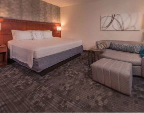 Double bed guest room in Sonesta Select Arlington Rosslyn, furnished with wall art, sofa, and coffee table.