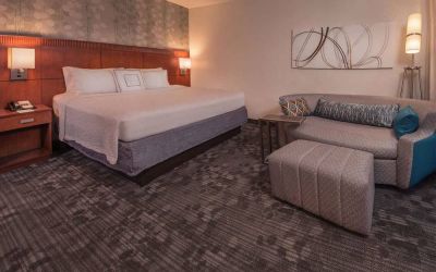 Double bed guest room in Sonesta Select Arlington Rosslyn, furnished with wall art, sofa, and coffee table.