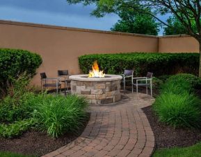 The hotel’s fire pit has chairs and abundant greenery around it.
