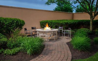 The hotel’s fire pit has chairs and abundant greenery around it.