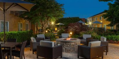 Sonesta Select Chattanooga Hamilton Place’s outdoor fire pit is ringed by armchairs and has pleasant greenery nearby.