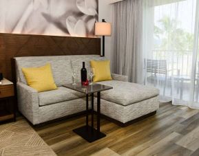 Guest room in Royal Sonesta Kaua'i Resort Lihue, featuring corner sofa, coffee table, and balcony.