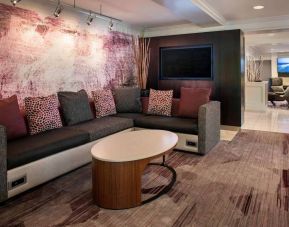 The hotel’s lobby has comfortable sofa seating, a coffee table, and large widescreen television.