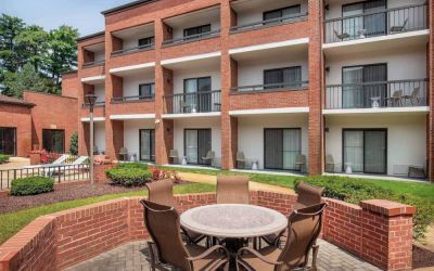 The hotel patio is close to the rooms, and has a circular table surrounded by a quintet of chairs.