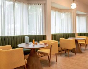 The hotel’s breakfast area has comfy seating, stylish tables, and large windows.