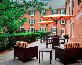 The hotel’s patio has armchairs and coffee tables, plus shaded tables and chairs.