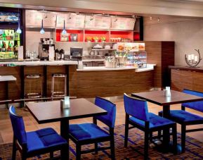 Breakfast area in Sonesta Select Boston Danvers, with seating at small tables or tall bar stools, and a range of healthy options.