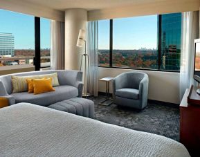 Sonesta Select Atlanta Cumberland Galleria double bed guest room, featuring sofa, chair, windows, and TV.