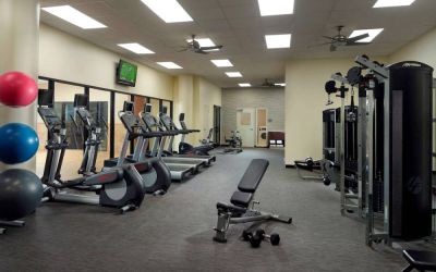 The hotel fitness center has an assortment of exercise machines, plus free weights and benches, and a wall-mounted TV.
