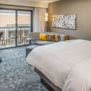 Double bed guest room in Sonesta Select Seattle Bellevue Redmond, furnished with chair, desk, and sofa.