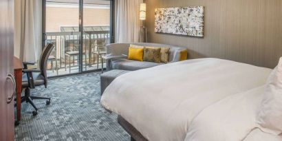 Double bed guest room in Sonesta Select Seattle Bellevue Redmond, furnished with chair, desk, and sofa.