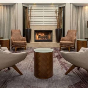 Sonesta Select Seattle Bellevue Redmond’s lobby includes coffee tables and comfy chairs close to a fireplace.