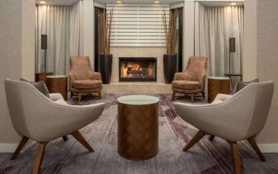 Sonesta Select Seattle Bellevue Redmond’s lobby includes coffee tables and comfy chairs close to a fireplace.