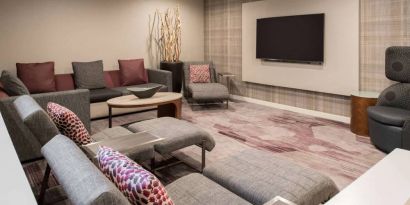 The lobby in Sonesta Select Seattle Bellevue Redmond features an enormous television, comfortable seating and coffee tables.