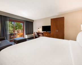 Double bed guest room in Sonesta Select San Jose Airport, with workspace desk and chair, plus TV.