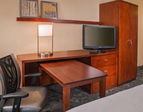 Guest room workspace in Sonesta Select Charlotte University Research Park, including desk, chair, and television.
