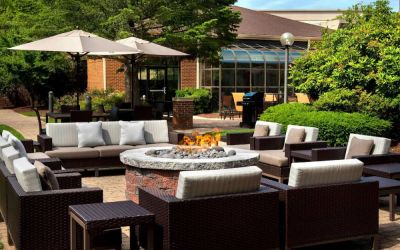 The hotel’s fire pit is surrounded by sofas and armchairs, and plenty of coffee tables, with pleasant greenery in the background.
