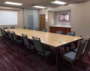 Meeting room in Sonesta Select Boston Milford, furnished with seating for 16 attendees, a long table, and a whiteboard.