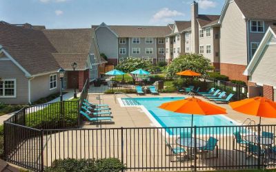 Sonesta ES Suites Baltimore BWI Airport’s outdoor pool is ringed by a fence, within which there are sun loungers, plus shaded tables and chairs.
