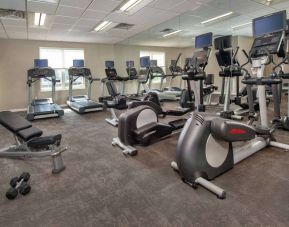 The fitness center in Sonesta ES Suites Baltimore BWI Airport is equipped with free weights and a bench alongside an assortment of exercise machines.
