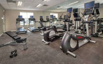 The fitness center in Sonesta ES Suites Baltimore BWI Airport is equipped with free weights and a bench alongside an assortment of exercise machines.