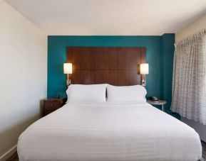 Double bed guest room in Sonesta ES Suites Chicago Downtown Magnificent Mile - Medical, with bedside lamps and window.
