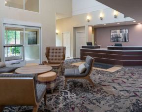 The lounge in Sonesta ES Suites Nashville Brentwood’s lobby features a quartet of comfy chairs, a snazzy carpet, and a coffee table. 