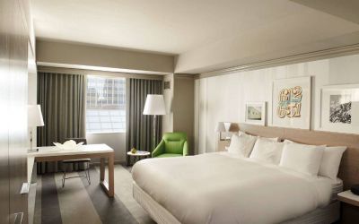 Royal Sonesta Minneapolis Downtown deluxe king guest room, with workspace desk and chair, and art on the wall.