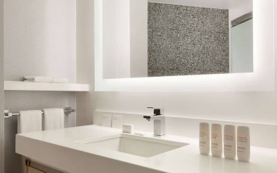 Guest bathroom in the hotel, including a range of toiletries, towels, and a sink.
