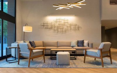 Sonesta Silicon Valley’s lobby is furnished with a comfortable sitting area, with long sofa, chairs, and multiple coffee tables.